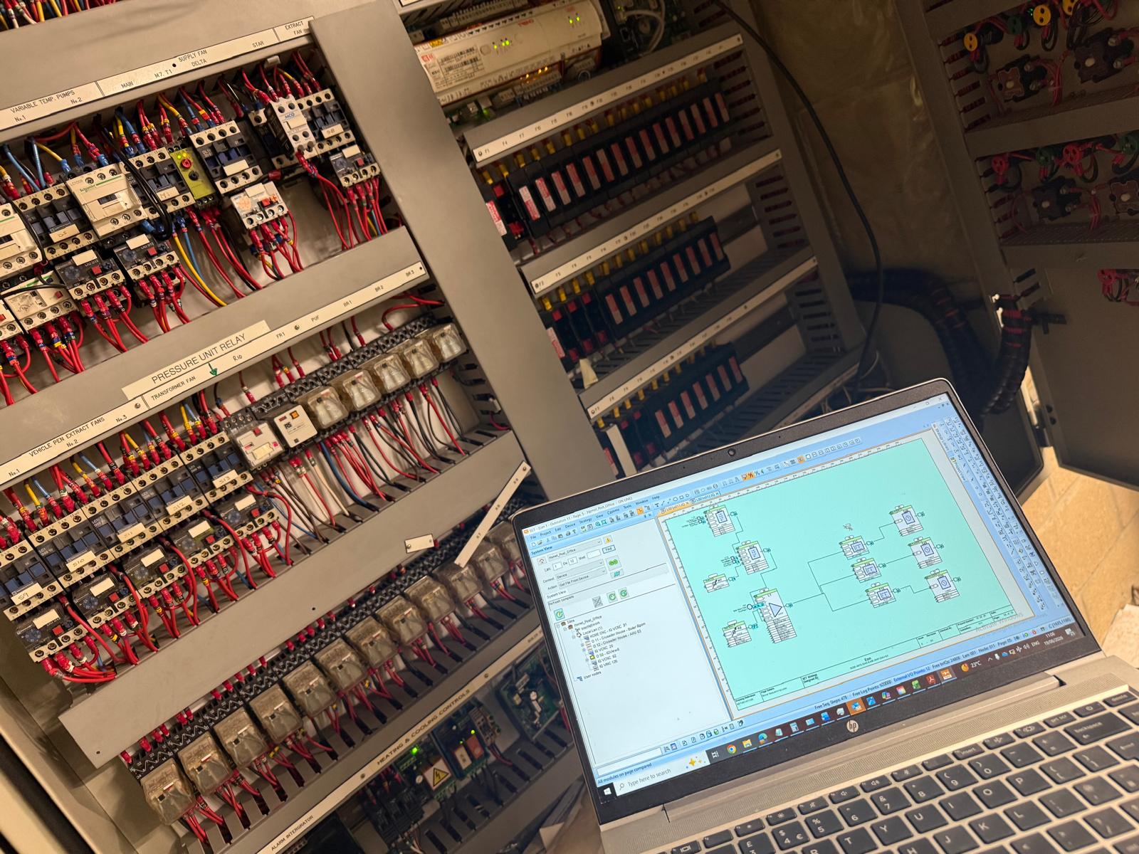 BIAV Controls laptop running Trend IQVision alongside a legacy Trend IQ BMS panel during a scheduled service visit